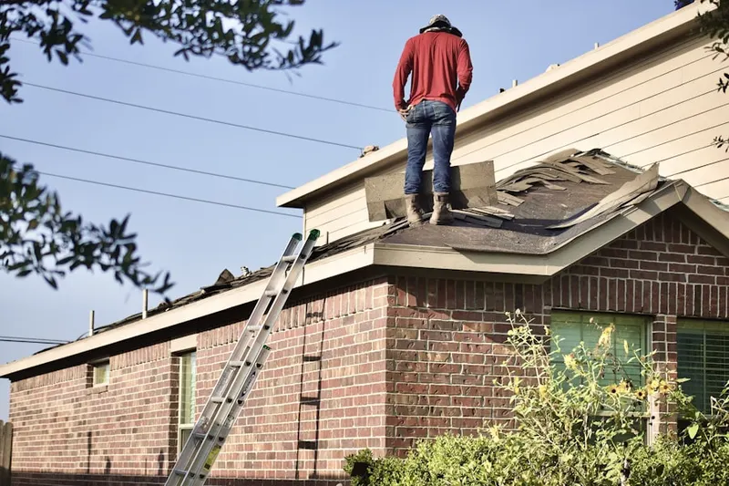 Professional roofer working on a residential roof in Woodard